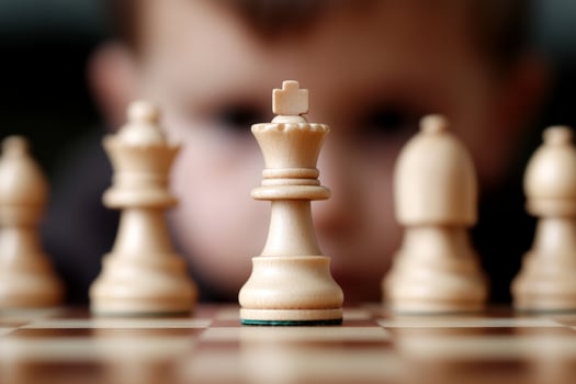 A child is looking at a chess board with a king on it photo