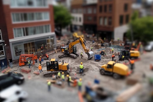 A miniature construction site with construction equipment and people photo