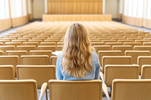 A woman sitting in an empty auditorium photo