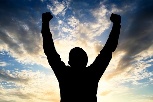 A man is silhouetted against a sky with clouds in the background photo