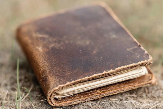 An old leather book sitting on the ground photo