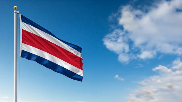 national flag of costarica waving on the wind, banner in the blue sky photo