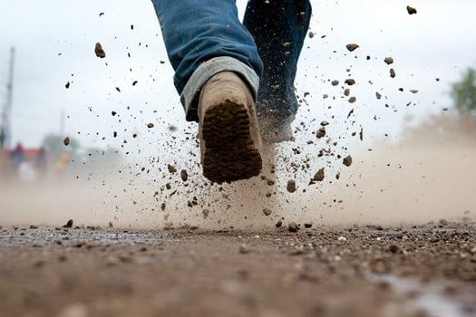 A person's feet are running through a muddy field photo
