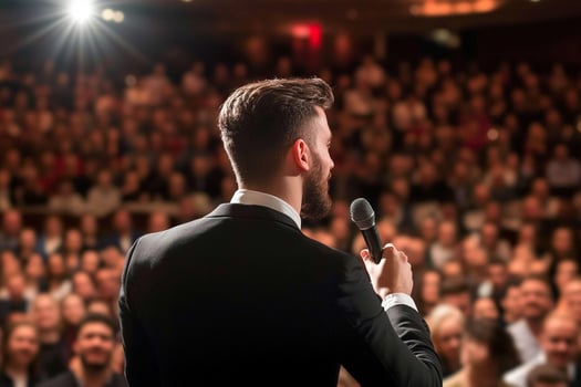 A man in a suit is speaking into a microphone photo