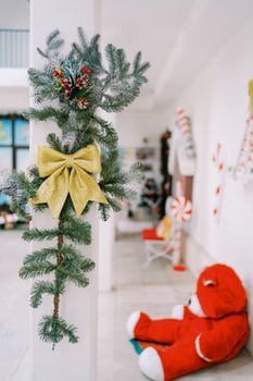 Pillar decorated with a garland and a bow against the background of New Year decor photo