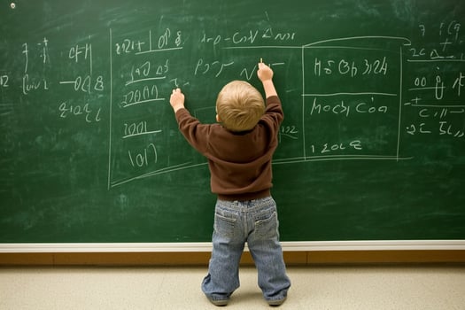 A young boy writing on a blackboard photo