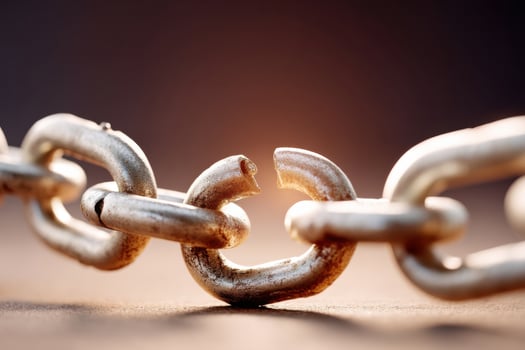 Broken metal chain on brown background representing broken promises and lost friendships photo
