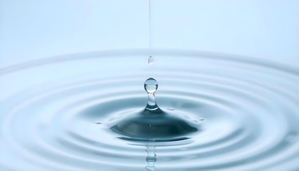 Water drop with ripple on blue background photo