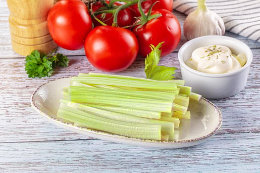 Celery sticks and tomatoes on a wooden table photo