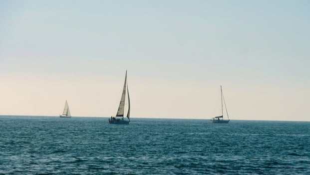 Three sailboats enjoying a calm day at sea photo