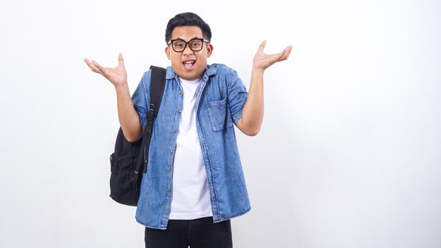 Surprised young Asian male university student in casual outfit with backpack isolated on white background photo