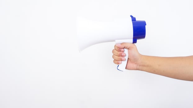 Close up of hand holding a megaphone isolated on white background photo