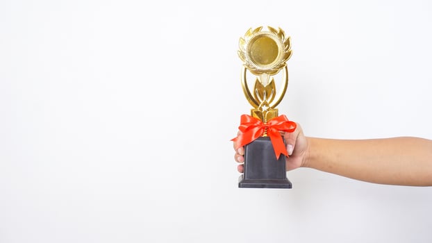 Close up of man hand holding trophy isolated on white background photo