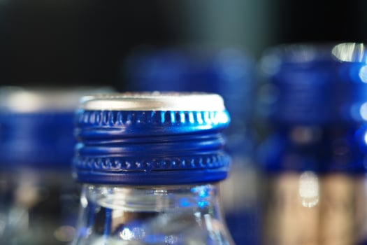 Close-up view of blue bottle caps on glass containers in focus photo