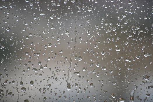 A close-up view of raindrops creating an artistic pattern on a window, a rainy day. photo