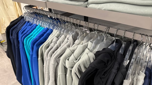 Colorful sweaters on hangers in clothing store, fashion retail concept, perfect for winter wardrobe and holiday shopping photo