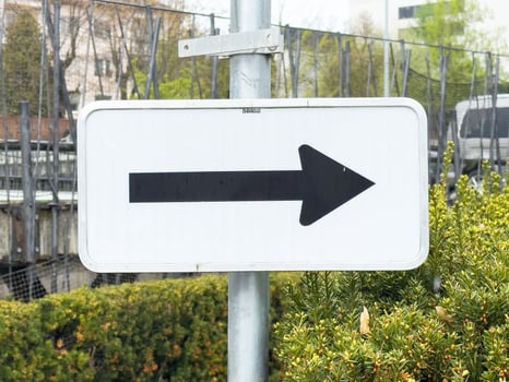 Black arrow traffic sign in urban setting pointing right photo