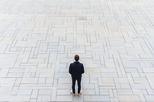 A man standing on a tiled floor looking at something photo