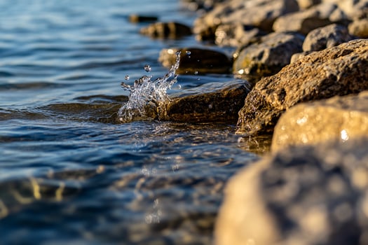 A rock wall and water splashing on it photo
