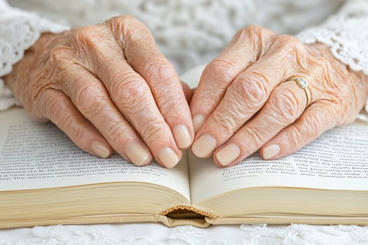 An elderly woman's hands are holding an open book photo