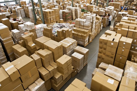 A large warehouse filled with boxes and people photo