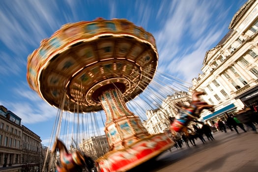 A carousel ride is moving in a city photo