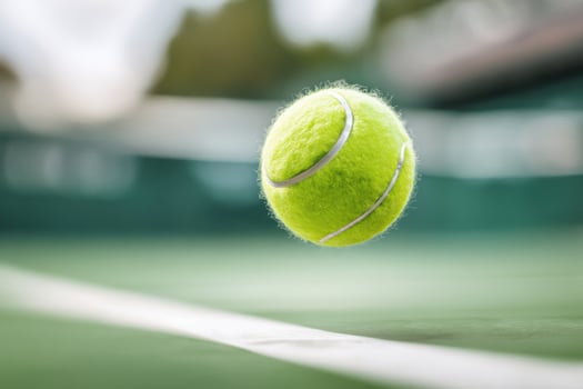 Tennis ball flying over the net during a serve on a sunny day photo