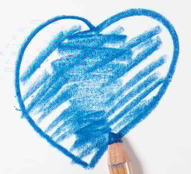 Heart drawn with blue pencil on white paper, close up photo