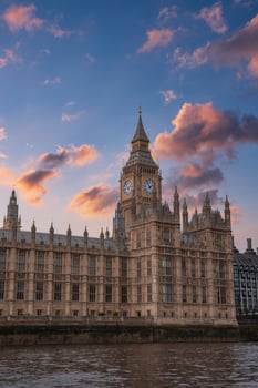 Elizabeth Tower, known as Big Ben, with Gothic Revival architecture, stands by the River Thames under a pink and orange sunset sky in London, England. photo