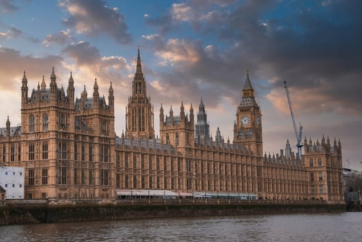 The Palace of Westminster and Big Ben in London, England, with Gothic Revival architecture, a dramatic sky, and the River Thames in the foreground. photo