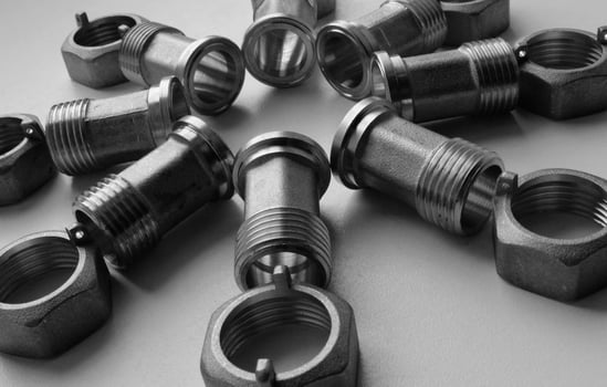 Cast Iron Water Plumbing Fittings And Fixing Nuts Laid Out On White Surface photo