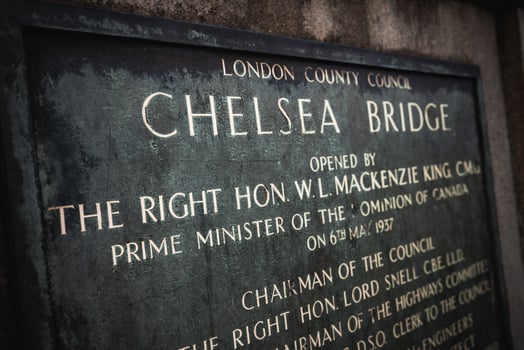 A historic plaque by London County Council marking Chelsea Bridge's 1937 opening by Canadian Prime Minister W.L. Mackenzie King, with gold engraved text. photo
