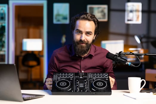Content creator filming technology review of newly released DJ controller, unboxing it, excited to look at specifications. Influencer showcasing sound mixer device to viewers photo
