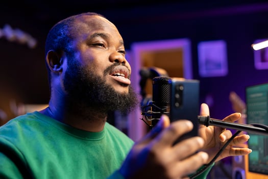 Artist producer performing acoustic version on his new track, editing the tunes with mixing console in home studio. Young singer recording songs on microphone, creative lyrics. Close up. photo