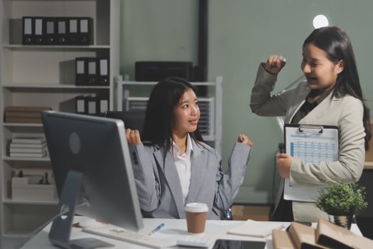 Two women in an office setting with a computer photo