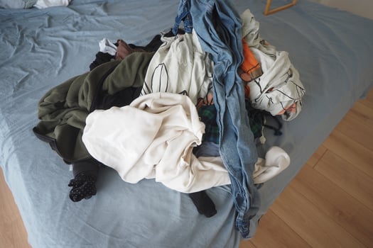 Clothes piled on bed after laundry day at home photo