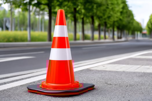 Orange traffic cone standing on asphalt road warning sign photo