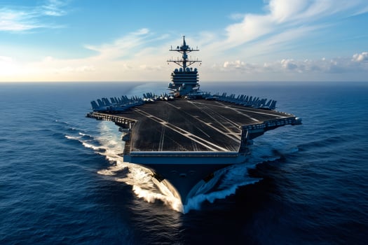 Nuclear powered aircraft carrier cruising in the ocean at sunset photo