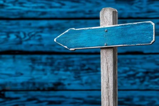 Empty blue wooden sign showing left direction on blue wooden background photo