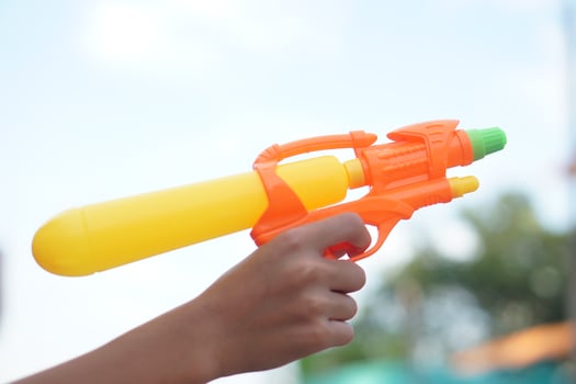 Hand holds a colorful plastic toy gun or a squirt gun, ready to shoot water for playful fun. This popular toy is a favorite among children and widely used during Songkran Festival celebrations. photo