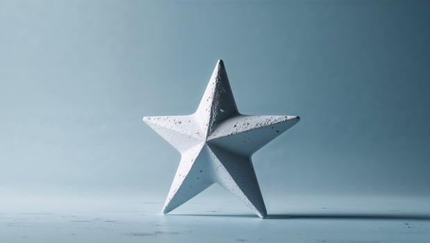 A textured white star rests upon a blue background surface photo