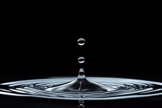 A Single Water Droplet Falling Into Still Water photo