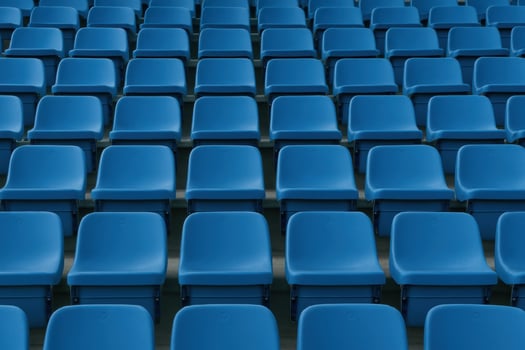 Symmetrical blue plastic stadium seats under soft diffused daylight atmosphere photo