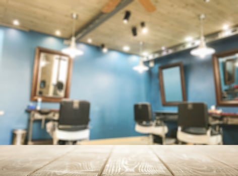 A barber chair and table in a room with blue walls photo