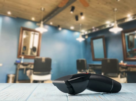 A barber chair with a black hair dryer on a wooden table photo