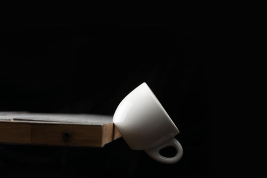 A white cup sitting on top of a wooden table photo