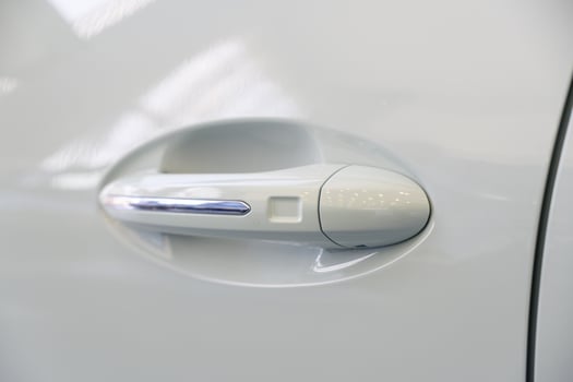 Close-up view of a modern car's door handle, featuring a white design photo