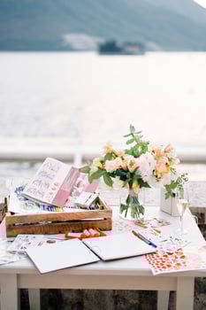 Reception table with a journal of wishes, a set of pencils, markers, beautiful stickers and a bouquet of flowers photo