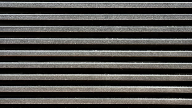 Close up pattern of horizontal metallic ventilation grill slats texture photo