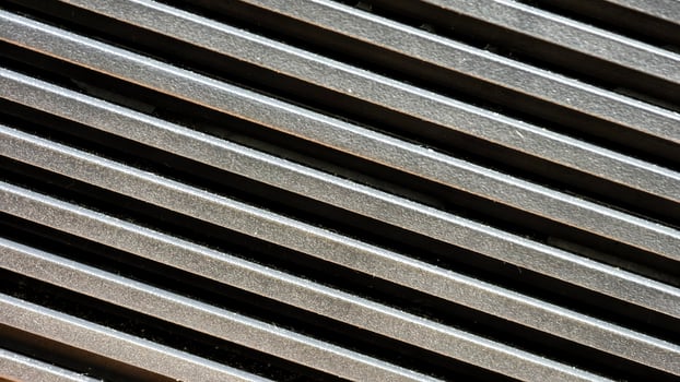 Diagonal Close-Up of Metallic Vent Grille with Strong Contrast and Texture photo